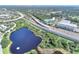 Expansive aerial view of the blue condo building, adjacent highway, and a nearby lake, blending urban access with natural beauty at 3315 58Th S Ave # 314, St Petersburg, FL 33712