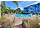 Beautiful community pool area with lush landscaping and clear blue water, with building in the background at 3315 58Th S Ave # 314, St Petersburg, FL 33712