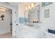 Charming bathroom with shiplap walls, marble-topped vanity, and a large mirror, providing a bright and welcoming space at 4400 37Th S St # 2, St Petersburg, FL 33711