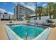Sparkling community pool surrounded by palm trees, lounge chairs, and modern condo buildings at 4400 37Th S St # 2, St Petersburg, FL 33711
