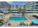 Community in-ground pool offering lounge chairs and outdoor dining with palm tree views at 4400 37Th S St # 2, St Petersburg, FL 33711