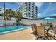 Community pool area boasts ample seating and shade, surrounded by lush palms and modern condos at 4400 37Th S St # 2, St Petersburg, FL 33711