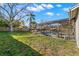 Home's lush backyard with lawn, mature trees and screened-in pool at 5005 Parrish Ln, Safety Harbor, FL 34695