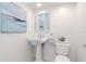 Simple powder room featuring a pedestal sink, decorative mirror, and neutral decor at 6014 Mariners Watch Dr, Tampa, FL 33615