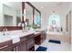 Elegant bathroom with dual sinks, marble countertops, and a decorative, arched window at 6014 Mariners Watch Dr, Tampa, FL 33615