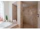 Modern bath with tile, dual shower heads, and decorative window view of the soaking tub at 6014 Mariners Watch Dr, Tampa, FL 33615