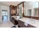 Luxurious bathroom featuring dual vanities, dark wood cabinets, and access to the pool area at 6014 Mariners Watch Dr, Tampa, FL 33615