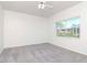 Bright bedroom with a ceiling fan, a window with an outdoor view, and carpet floors at 6014 Mariners Watch Dr, Tampa, FL 33615