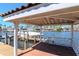 Covered boat dock featuring a seating area and boat lift, ideal for enjoying waterfront activities at 6014 Mariners Watch Dr, Tampa, FL 33615