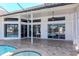 The covered outdoor patio features ceiling fans, tiled floors, and sliding glass doors, perfect for relaxing with pool access at 6014 Mariners Watch Dr, Tampa, FL 33615