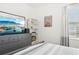 Bedroom features a modern dresser with a TV, bright window with coverings, and neutral wall colors at 6251 Camino Dr, Apollo Beach, FL 33572