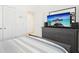 Bedroom boasts a gray dresser with a TV, an off-white closet, and a serene view at 6251 Camino Dr, Apollo Beach, FL 33572