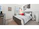 Comfortable bedroom with a striped bedspread, window with blinds, and decorative wall art at 6251 Camino Dr, Apollo Beach, FL 33572
