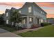 Charming two-story home with manicured lawn and inviting front porch at sunset at 6251 Camino Dr, Apollo Beach, FL 33572