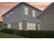 Charming two-story home with manicured landscaping and light blue siding at sunset at 6251 Camino Dr, Apollo Beach, FL 33572