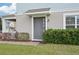 Home's front entrance with a gray front door and green, manicured bushes at 6251 Camino Dr, Apollo Beach, FL 33572