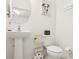 Quaint powder room with a pedestal sink, toilet, and charming decor at 6251 Camino Dr, Apollo Beach, FL 33572