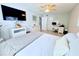Spacious bedroom features a ceiling fan, television, and a work space with white wood furniture at 6398 17Th N Pl, St Petersburg, FL 33710
