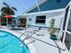 Relaxing pool area with a colorful umbrella, chairs, and tropical decorations, perfect for enjoying the weather at 6398 17Th N Pl, St Petersburg, FL 33710