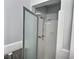 Bright white shower with modern shower head, frosted sliding door and ceramic tile surround at 6398 17Th N Pl, St Petersburg, FL 33710