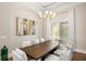 Dining area with a dark wood table, modern chandelier, and natural light at 6520 Surfside Blvd, Apollo Beach, FL 33572