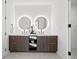 Bathroom with a double sink vanity, round lighted mirrors, and a glass-enclosed shower area at 777 3Rd N Ave # 805, St Petersburg, FL 33701