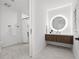 Modern bathroom with a floating vanity, round lighted mirror, and glass shower at 777 3Rd N Ave # 805, St Petersburg, FL 33701