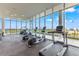 A brightly-lit gym is equipped with cardio machines facing floor-to-ceiling windows with blue sky views at 777 3Rd N Ave # 805, St Petersburg, FL 33701