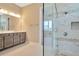 Bathroom featuring a double vanity and frameless glass shower with decorative accents and a neutral palette at 10432 Torchwood Sea Way, San Antonio, FL 33576