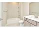 Bathroom with white tile, white vanity, tub and shower combination with gray walls at 10432 Torchwood Sea Way, San Antonio, FL 33576