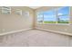 Bright bedroom featuring large windows with scenic neighborhood views and plush carpeting at 10432 Torchwood Sea Way, San Antonio, FL 33576