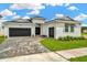 Charming single-story home featuring a paver driveway, two car garage, manicured lawn, and modern design at 10432 Torchwood Sea Way, San Antonio, FL 33576