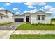 Beautiful single-story home with a well-manicured lawn, a paver driveway, and a modern black garage door at 10432 Torchwood Sea Way, San Antonio, FL 33576