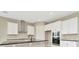Modern kitchen featuring sleek white cabinets, stainless steel appliances, and elegant black countertops at 10432 Torchwood Sea Way, San Antonio, FL 33576