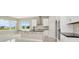 Bright, modern kitchen boasts white cabinets, a black countertop island, and stainless steel appliances at 10432 Torchwood Sea Way, San Antonio, FL 33576