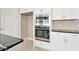 Modern kitchen with stainless steel appliances, black countertops, and white cabinets at 10432 Torchwood Sea Way, San Antonio, FL 33576