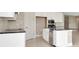 Contemporary kitchen boasts stainless steel appliances, white cabinets, and an island with seating at 10432 Torchwood Sea Way, San Antonio, FL 33576