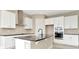 Modern kitchen featuring a center island, white cabinetry, black countertops and stainless steel appliances at 10432 Torchwood Sea Way, San Antonio, FL 33576
