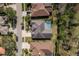 Overhead shot of homes with driveways and landscaping; one home features a distinctive roof design and screened-in pool at 10537 Greensprings Dr, Tampa, FL 33626