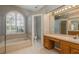 Primary bathroom with soaking tub under arched window, and oak vanity at 10537 Greensprings Dr, Tampa, FL 33626