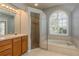 Bathroom with a soaking tub, walk-in shower, and a large window with natural light at 10537 Greensprings Dr, Tampa, FL 33626