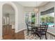 Open-concept dining room overlooking the pool area, featuring hardwood floors, an area rug and a modern chandelier at 10537 Greensprings Dr, Tampa, FL 33626