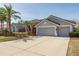 Spacious driveway leading to a three-car garage, surrounded by manicured landscaping at 10537 Greensprings Dr, Tampa, FL 33626