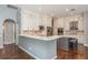 Modern kitchen with white cabinets, stainless steel appliances, and a breakfast bar with seating overlooking the rest of the house at 10537 Greensprings Dr, Tampa, FL 33626