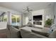 Bright living room with stone fireplace, large TV, and sliding door access to pool at 10537 Greensprings Dr, Tampa, FL 33626