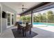 Covered patio featuring an outdoor dining table and seating overlooking the screened in pool at 10537 Greensprings Dr, Tampa, FL 33626