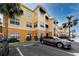 Exterior view of a condo building with a parking area and palm trees at 10764 70Th Ave # 5101, Seminole, FL 33772