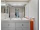 Bathroom featuring a double sink vanity, large mirror, and access to walk-in closet at 128 Nancy Dr # 128, Oldsmar, FL 34677