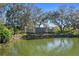 East Lake Woodlands community sign surrounded by trees and overlooking a pond at 128 Nancy Dr # 128, Oldsmar, FL 34677