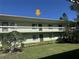 Exterior view of the residential building featuring a green exterior, and a well-manicured lawn at 128 Nancy Dr # 128, Oldsmar, FL 34677